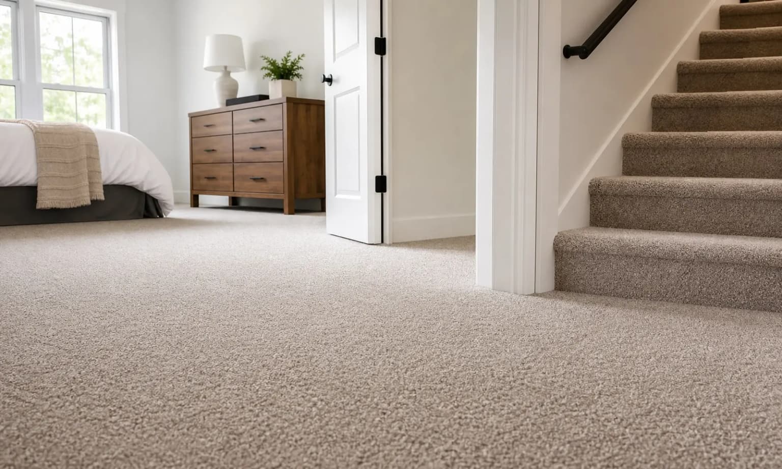 Plush broadloom carpet installed in a Toronto bedroom with carpeted staircase beyond